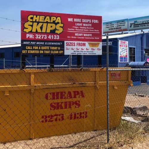 Skip bin hire Gold Coast - skip behind fence under sign
