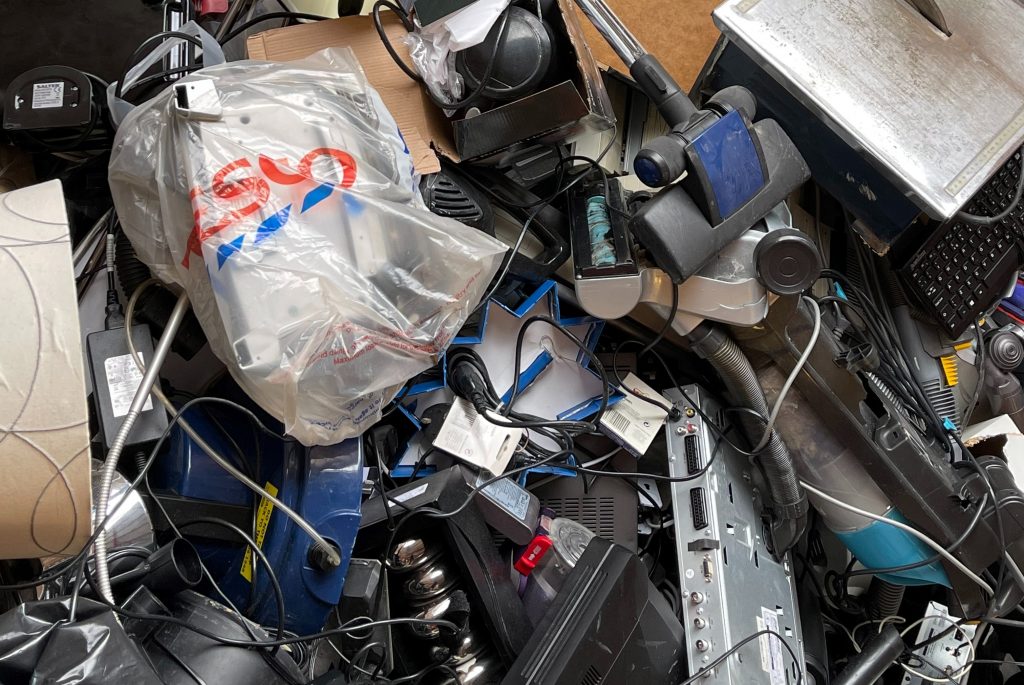 How To Properly Dispose Of E-Waste  - pile of old electronics waiting to be disposed of in  a skip bin